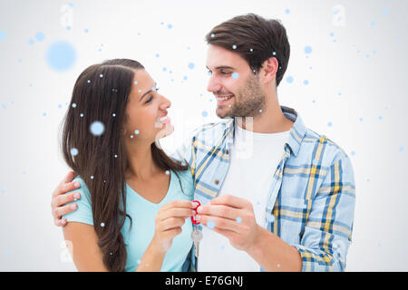 Immagine composita di felice coppia giovane azienda nuova chiave di casa Foto Stock