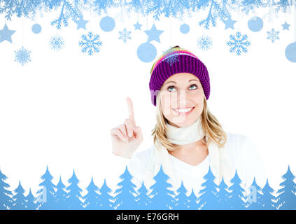 Immagine composita della giovane donna che indossa un cappello colorato rivolto verso l'alto con le sue dita Foto Stock