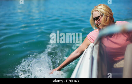 Donna anziana mano finale in acqua dalla barca Foto Stock
