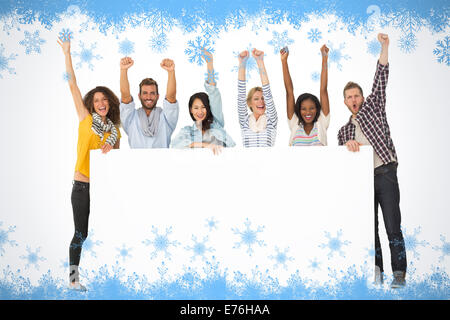 Immagine composita di sorridere un gruppo di giovani amici che mostra grandi poster e rasserenanti Foto Stock