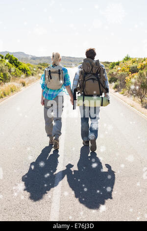 Immagine composita della coppia attraente a camminare sulla strada tenendo le mani Foto Stock
