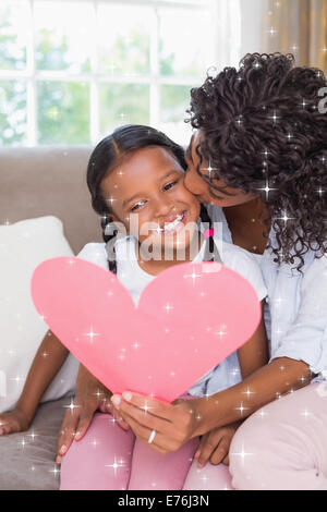 Immagine composita della bella madre seduta sul divano con la figlia di lettura scheda di cuore Foto Stock