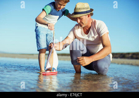 Nonno e nipote giocando con il giocattolo di barca in acqua Foto Stock