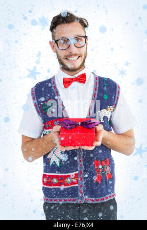 Immagine composita di geeky hipster offrendo regali di natale Foto Stock