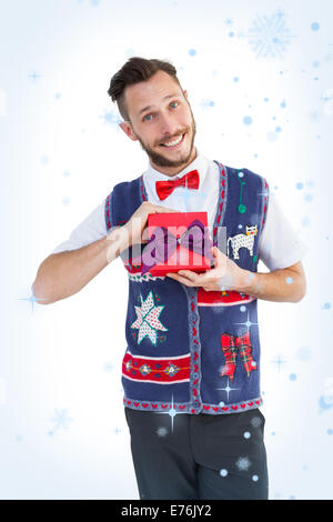 Immagine composita di geeky hipster offrendo regali di natale Foto Stock