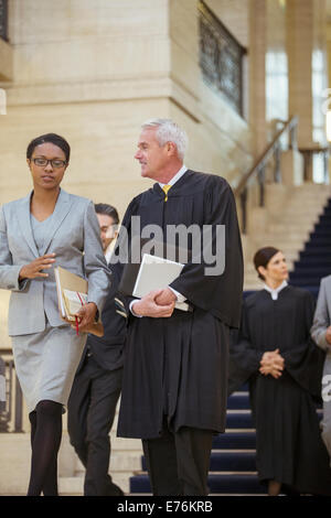 Giudice e avvocato camminare insieme attraverso courthouse Foto Stock