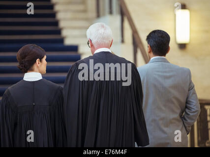 Giudici e avvocati a piedi attraverso courthouse insieme Foto Stock