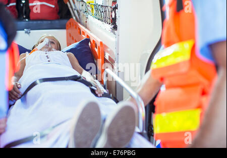 I paramedici esaminando il paziente sulla barella in ambulanza Foto Stock