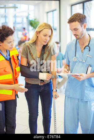 Infermiere e personale paramedico di parlare al paziente in ospedale Foto Stock