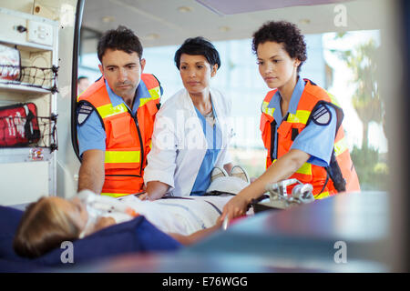 Medico e paramedico esame paziente in ambulanza Foto Stock