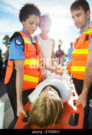 I paramedici che trasportano il paziente sulla barella Foto Stock