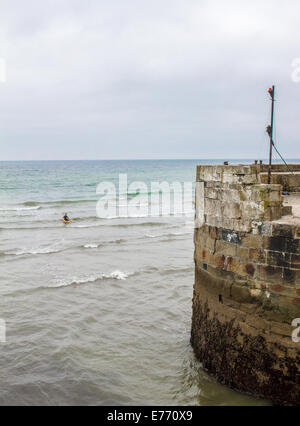 Un canoeist paddling fuori del porto di Charlestown, un villaggio ed un porto sulla costa meridionale della Cornovaglia, England Regno Unito Foto Stock