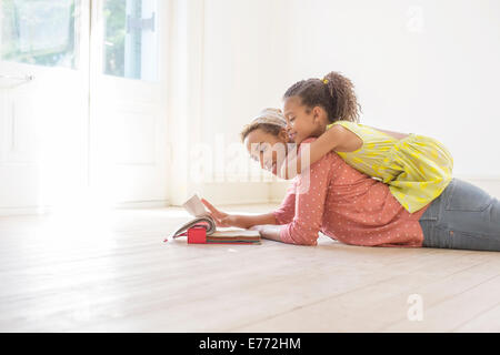 Madre e figlia guardando attraverso i campioni di tessuto insieme Foto Stock