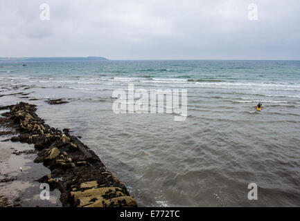 Un canoeist paddling fuori del porto di Charlestown, un villaggio ed un porto sulla costa meridionale della Cornovaglia, England Regno Unito Foto Stock