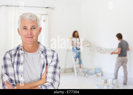 Vecchio Uomo sorridente con la famiglia a lavorare Foto Stock