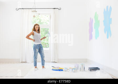 Donna pittura pareti in spazio abitativo Foto Stock