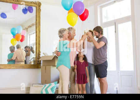 Famiglia celebrando con bevande e palloncini Foto Stock