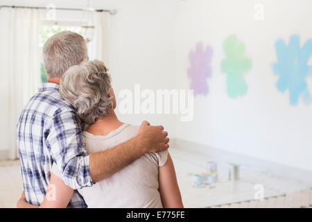 Coppia di anziani che si affaccia su campioni di vernice sulla parete Foto Stock