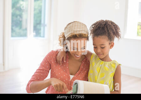 Madre e figlia guardando attraverso i campioni di tessuto insieme Foto Stock