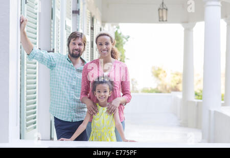 Famiglia sorridente sul portico insieme Foto Stock