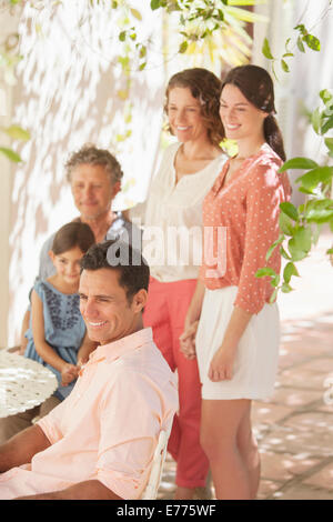 Famiglia riunita attorno al tavolo di gioco all'aperto Foto Stock