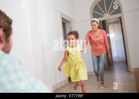 Madre e figlia che corre verso il padre Foto Stock