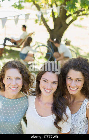 Tre donne abbracciando all'aperto Foto Stock