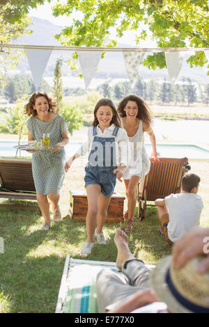 Famiglia in esecuzione attraverso il parco insieme Foto Stock