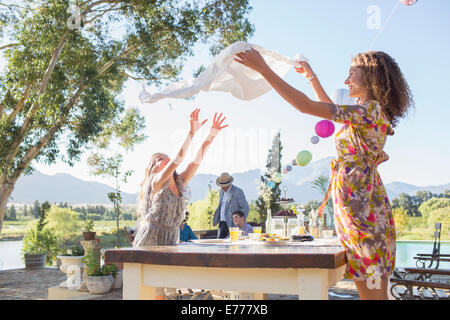 Madre e figlia che stabilisce la tabella panno sul tavolo Foto Stock