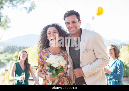 Famiglia di gettare il riso sulla sposa giovane Foto Stock