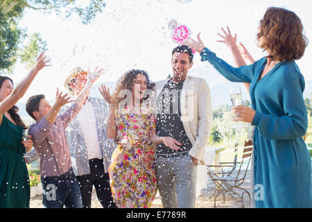 Famiglia gettando coriandoli sulla sposa giovane Foto Stock