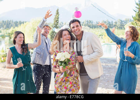 Famiglia di gettare il riso sulla sposa giovane Foto Stock