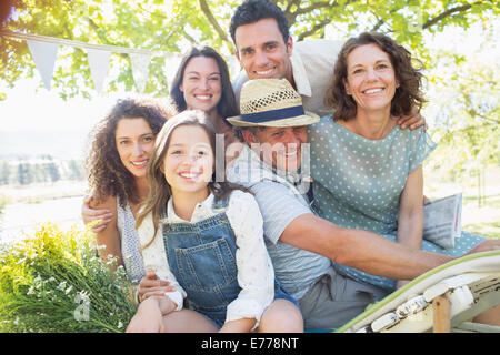 Famiglia abbracciando in esterni al picnic Foto Stock