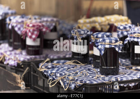 Molti barattoli per conserve con marmellata di scuro in un mercato. Filtrata orizzontale shot Foto Stock