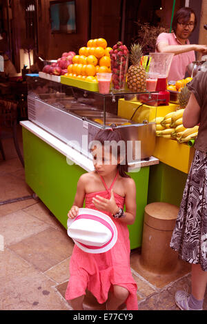 Little Girl holding white cappello di paglia nel mercato in Aix-en-Provence Francia Foto Stock