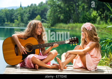 Ritratto di due giovani ragazze a cantare insieme a Lakeside. Foto Stock
