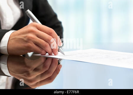 Extreme close up femmina mano business firma documento. Foto Stock