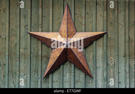 Metallo stella a cinque punte su una ruvida parete in legno Foto Stock