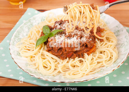 Spaghetti alla bolognese servita nella piastra sulla tavola di legno Foto Stock