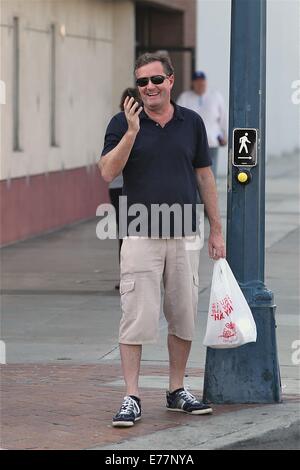 Piers Morgan indossando 3/4 lunghezza shorts attende prima di attraversare la strada con il suo asporto in un sacchetto di plastica, mentre prendendo una chiamata sul suo telefono cellulare dotato di: Piers Morgan dove: Los Angeles, California, Stati Uniti quando: 06 Mar 2014 Foto Stock