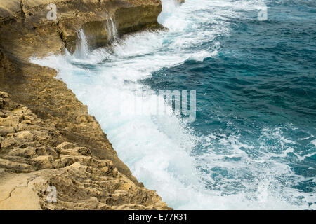 Onde che si infrangono contro la costa a Marsalforn sul Mediterraneo Isola di Gozo Foto Stock