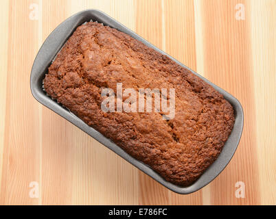 Appena sfornato focaccia di banane in un stagno rivestito su un tavolo di legno Foto Stock
