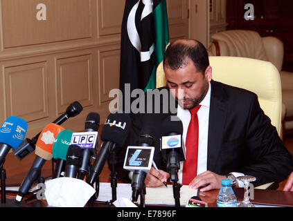 Tripoli, Libia. 9 Sep, 2014. Libia-islamico sostenuto il primo ministro Omar al-Hasi segni sulla sua carta di autorizzazione dopo il Generale uscente Congresso Nazionale (GNC) concessa la fiducia al nuovo governo, che è guidato da Omar al-Hasi e composta da 19 ministeri e tre supremi consigli, a Tripoli, in Libia, il 7 settembre 8, 2014. Libia l' ex-il parlamento ha formalmente autorizzato di islamisti-governo sostenuto nella città capitale di Tripoli il lunedì. Credito: Xinhua/Alamy Live News Foto Stock