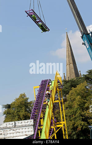 Witney, Oxfordshire, Regno Unito, 9 settembre 2014. Fiera dei lavoratori utilizzare una gru per impostare un rollercoaster ride in blazing sunshine in preparazione per la festa di Witney questo fine settimana. La festa annuale di Santa Maria è stato tenuto dal 1243 per commemorare il re-dedicazione della chiesa di Santa Maria quando il Vescovo ha dato un cervo al rettore di modo che la gente della città potrebbe festeggiare l'occasione. Oggi un arrosto di maiale sulla Chiesa ancora verde segna questa parte della tradizione accanto alle giostre e baracconi, chioschi, musica ed eventi sportivi Credito: Ric Mellis/Alamy Live News Foto Stock