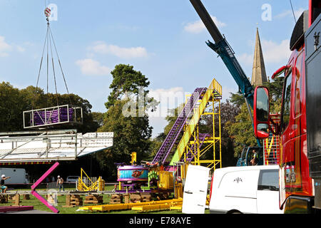 Witney, Oxfordshire, Regno Unito, 9 settembre 2014. Fiera dei lavoratori utilizzare una gru per impostare un rollercoaster ride in blazing sunshine in preparazione per la festa di Witney questo fine settimana. La festa annuale di Santa Maria è stato tenuto dal 1243 per commemorare il re-dedicazione della chiesa di Santa Maria quando il Vescovo ha dato un cervo al rettore di modo che la gente della città potrebbe festeggiare l'occasione. Oggi un arrosto di maiale sulla Chiesa ancora verde segna questa parte della tradizione accanto alle giostre e baracconi, chioschi, musica ed eventi sportivi Credito: Ric Mellis/Alamy Live News Foto Stock