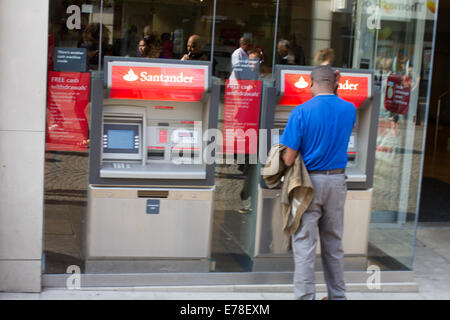 Un uomo con Santander bancomat a Sheffield, Regno Unito Foto Stock