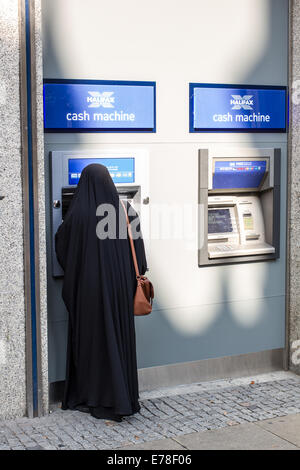 Una donna in burka utilizzando un bancomat a Sheffield, Regno Unito Foto Stock