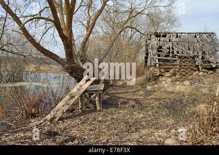 Paesaggi rustici con il vecchio tavolo in legno sotto agli alberi e sgangherate fienile dietro Foto Stock