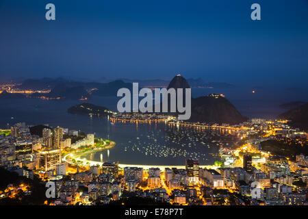 La baia e la città, e la Montagna Sugar Loaf al crepuscolo, Rio de Janeiro, Brasile Foto Stock