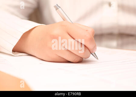 Imprenditrice la visualizzazione del contratto prima di firmare. Close-up. Focus sulla penna. Profondità di campo. Foto Stock